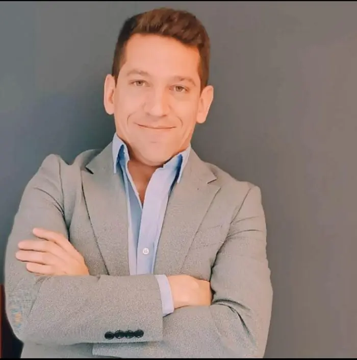 Gastón Bracco, agente inmobiliario de +Simple, de saco gris y brazos cruzados
